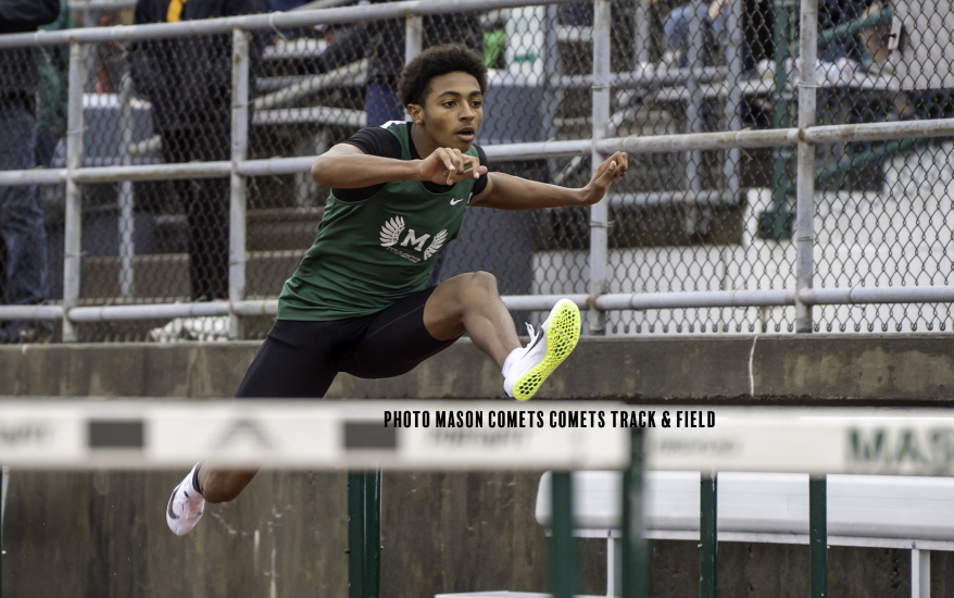 boy jumping over hurdle