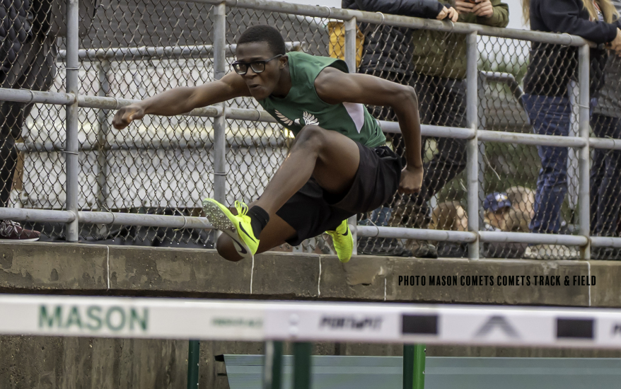 boy jumping over hurdle
