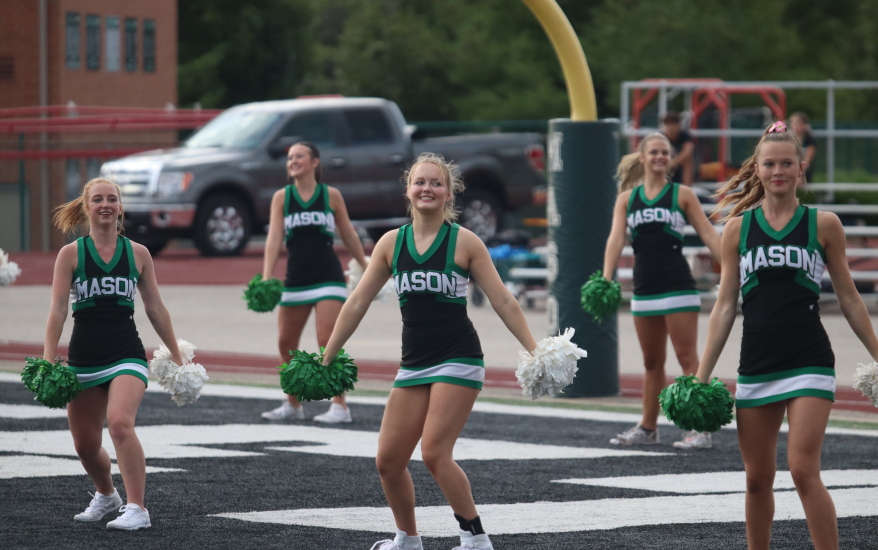 girls holding pompoms downwards