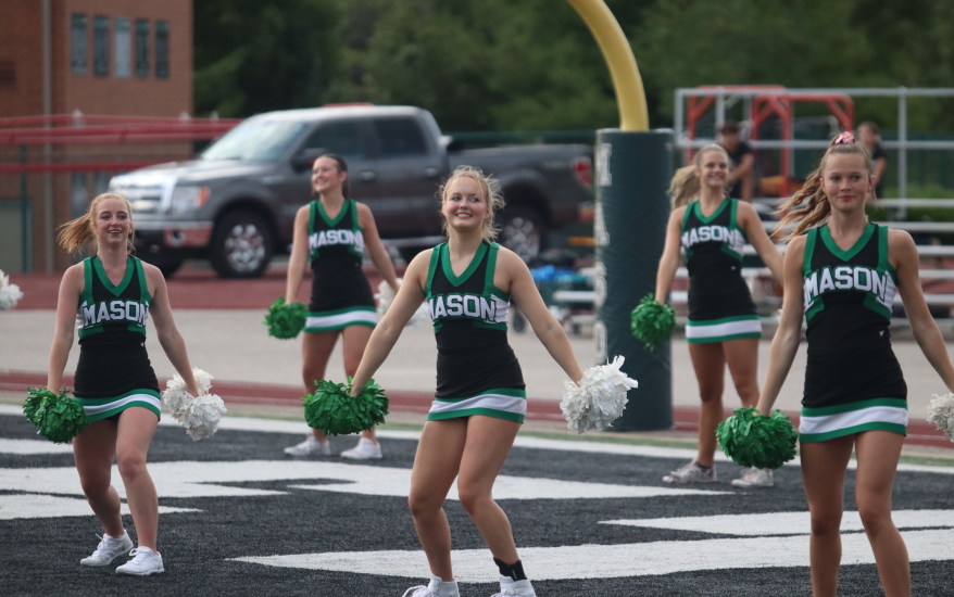 girls holding pompoms downwards