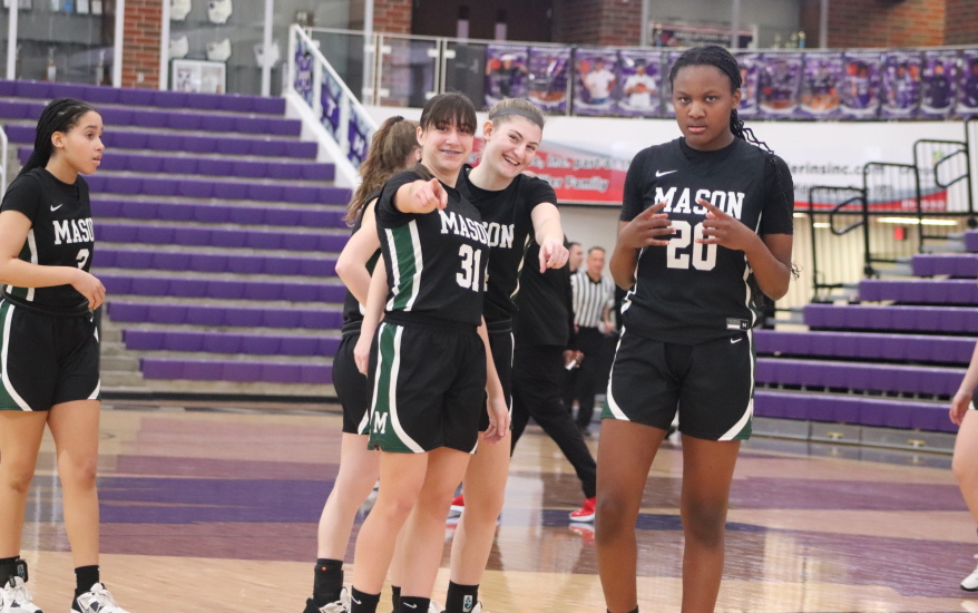 girls basketball team laughing looking and pointing towards camera