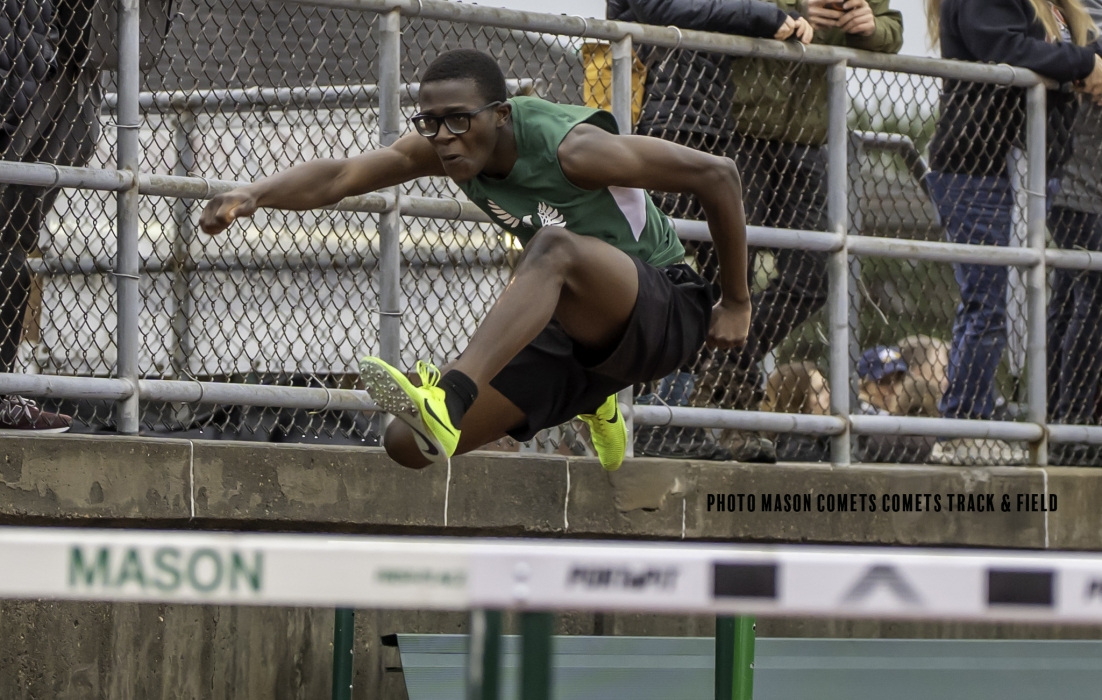 boy jumping over hurdle