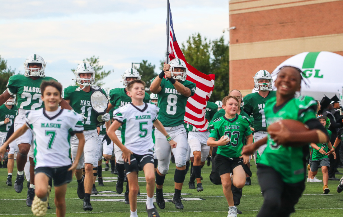 Football players running the field